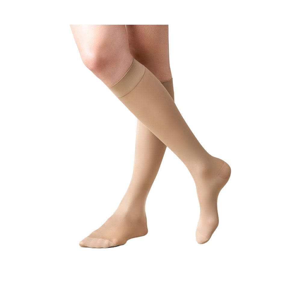 Hautfarbene Kniestrümpfe. Beinbekleidung mit verstärktem Fußteil und breitem Bund. Auf weißem Hintergrund.