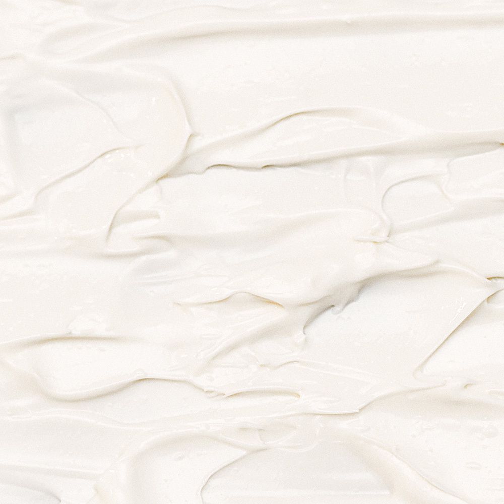 Nahaufnahme einer weißen Creme. Textur mit sichtbaren Pinselstrichen.