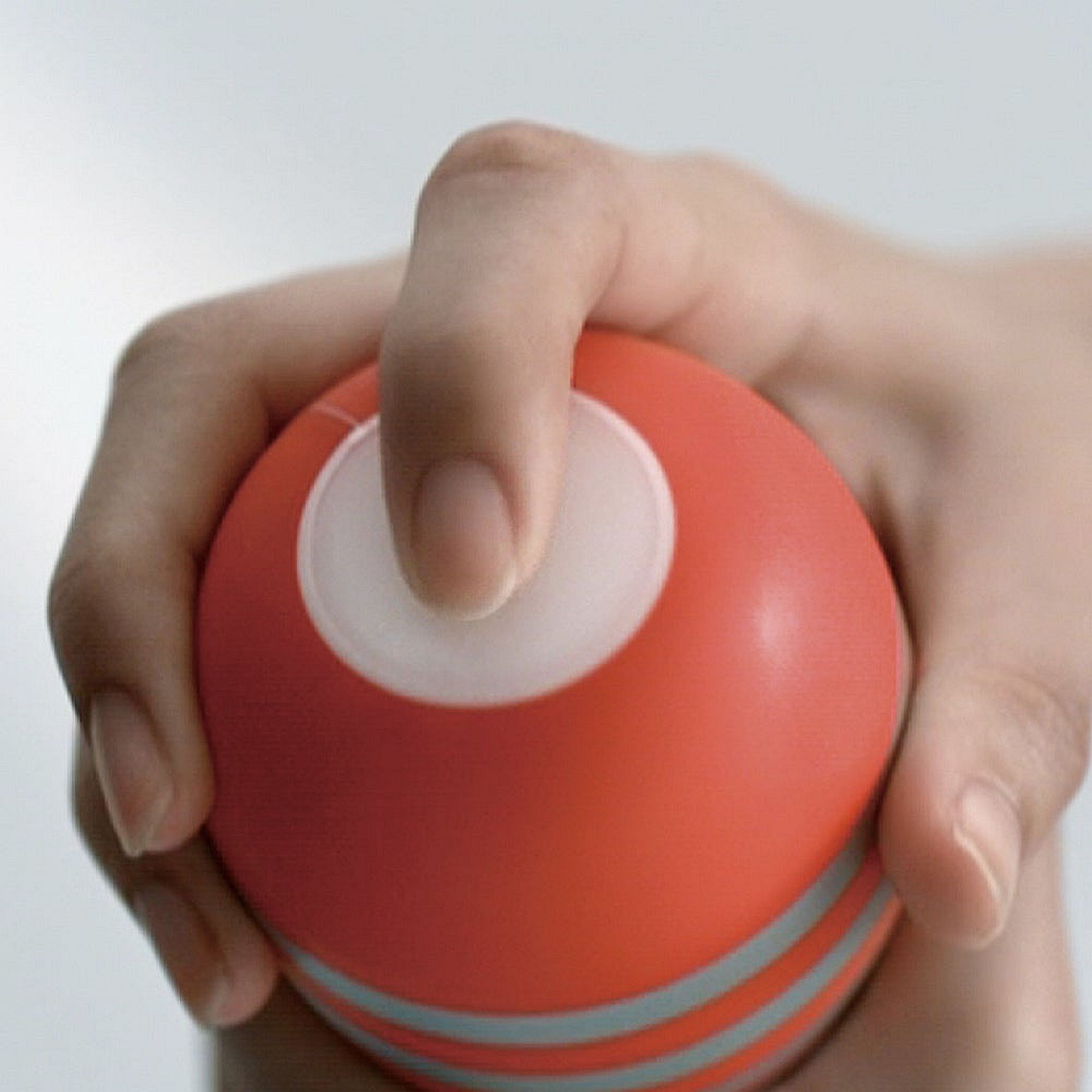 Hand hält einen roten Ball mit silbernen Streifen. Weißer Knopf oben.