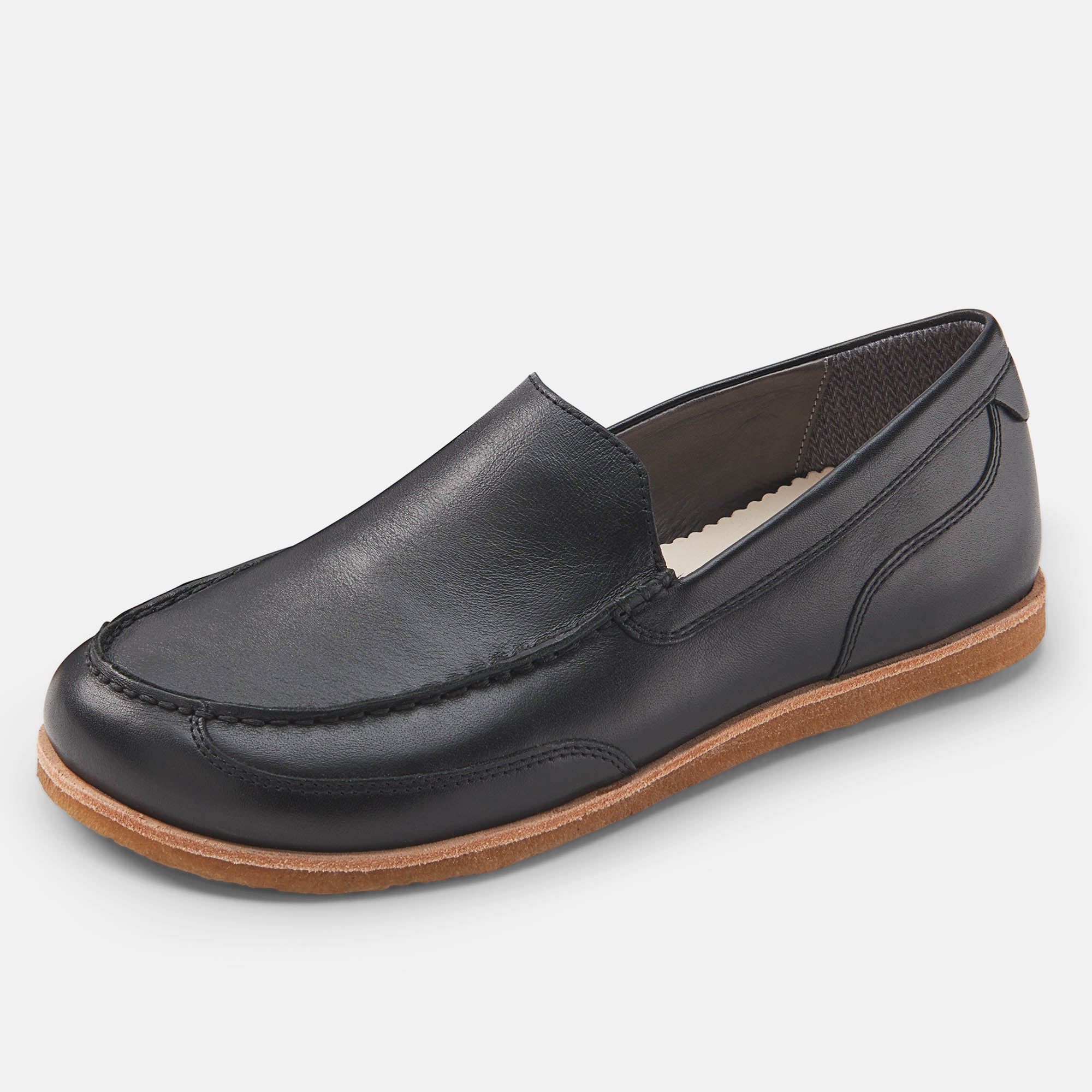 Schwarzer Slipper mit hellbrauner Sohle. Lederoptik, breite Passform. Nahtdetails.