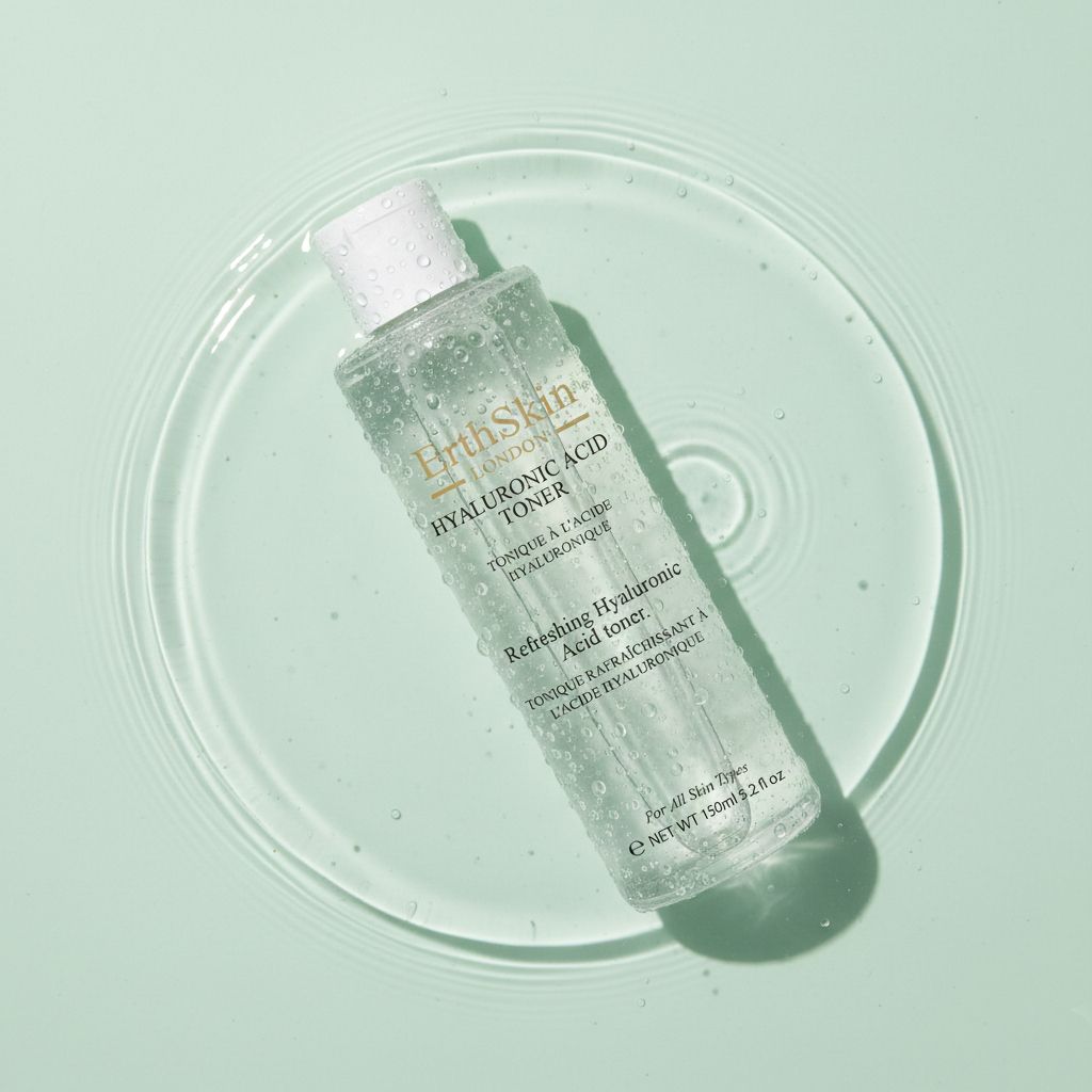 Erfrischender Hyaluronsäure-Toner von ErthSkin London in einer Flasche, umgeben von Wasser.