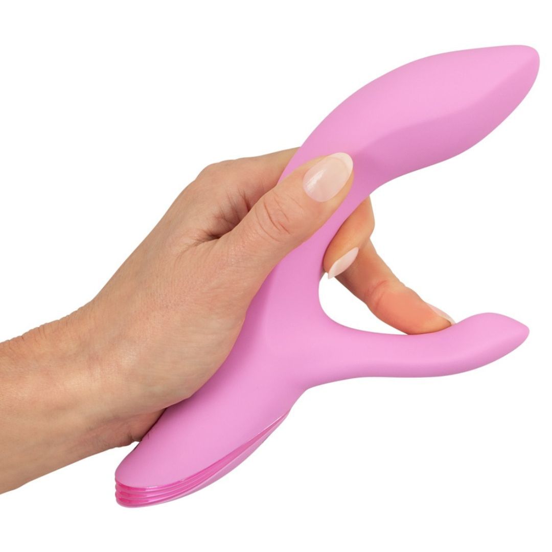 Rosa Vibrator in einer Hand gehalten. Gebogene Form mit einem zusätzlichen gebogenen Teil.