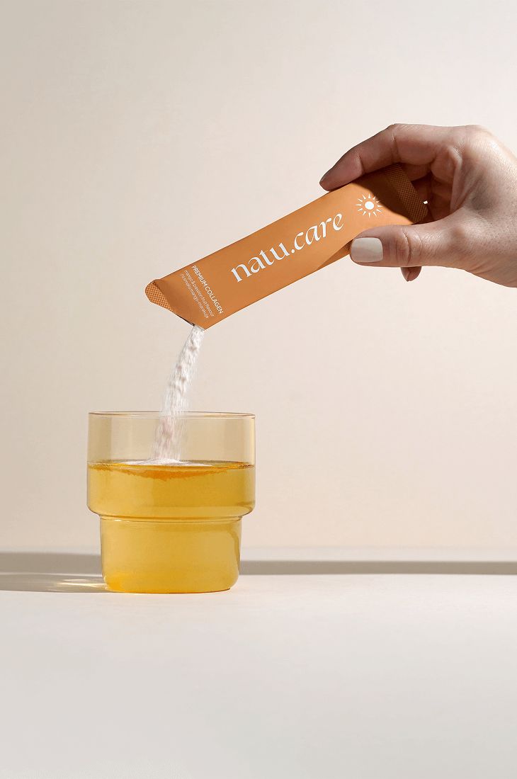 Hand hält Beutel mit Pulver über Glas. Aufschrift "natu.care". Pulver wird in Glas gegossen.