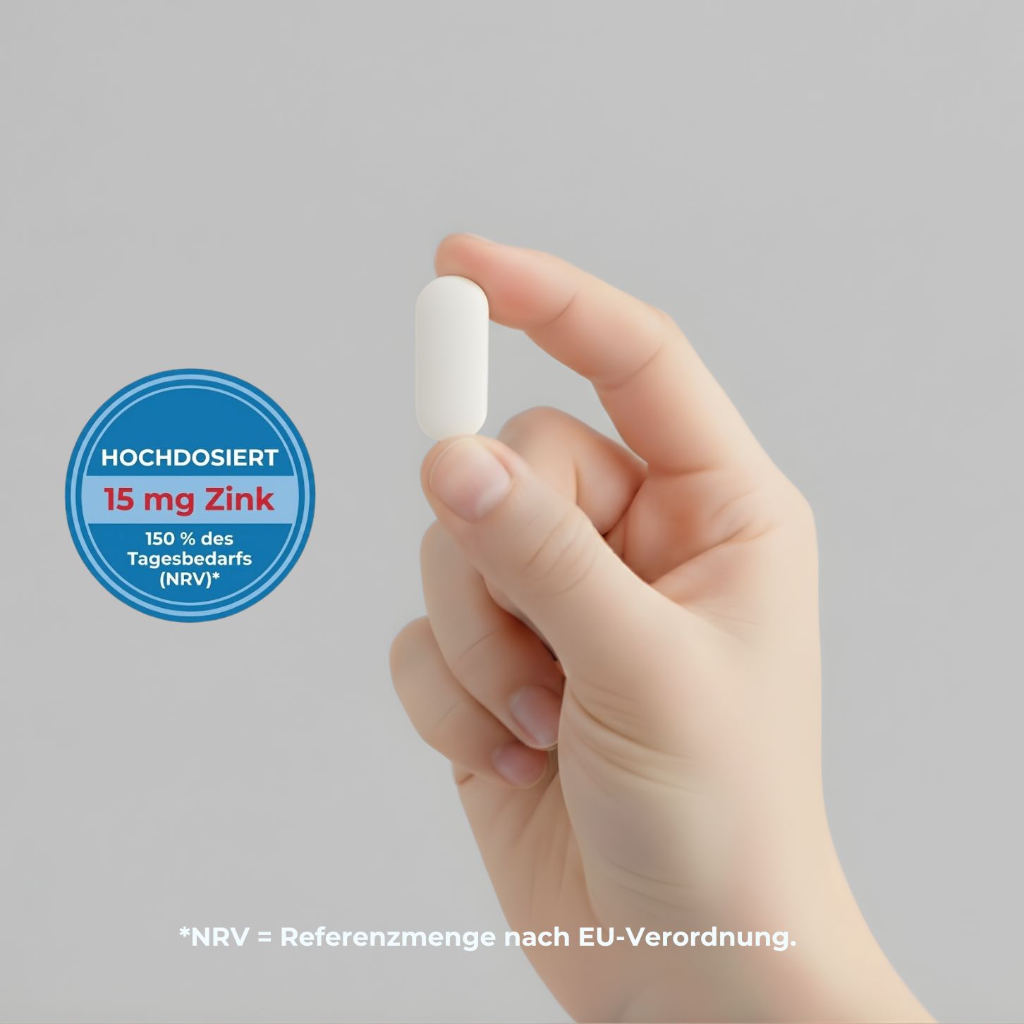 Hand hält eine weiße, ovale Tablette. Blaue Kreise mit Text: 15 mg Zink, 150% des Tagesbedarfs (NRV).