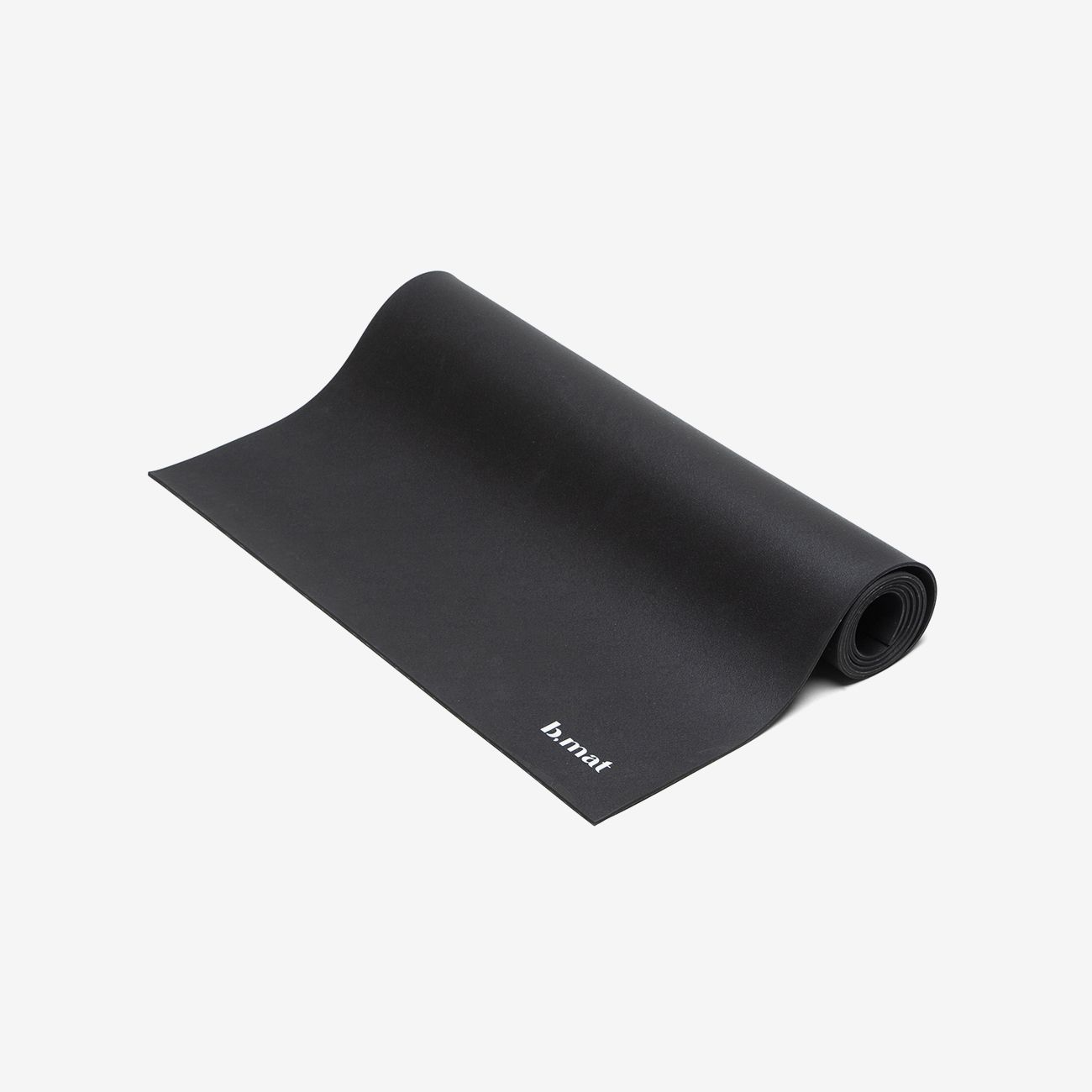Schwarze Yogamatte, teilweise gerollt. Auf der Matte ist der Schriftzug "b.mat" zu sehen.