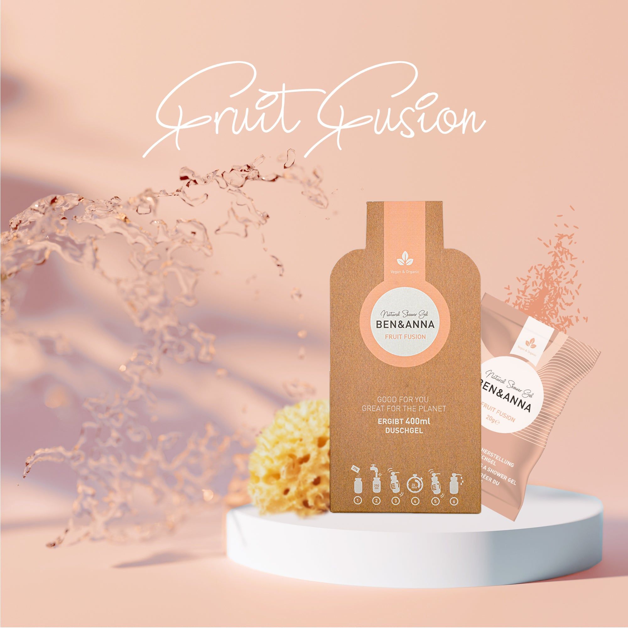 Confezione e busta "BEN&ANNA" e "Fruit Fusion" su piedistallo. Acqua e spugna sullo sfondo.