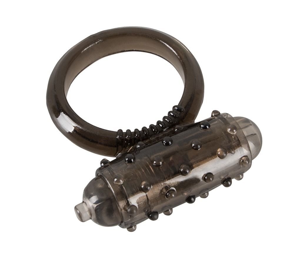 Dunkelgrauer Penisring mit Vibrationsfunktion. Ring und zylindrischer Aufsatz mit Noppen. Aufsatz mit kleiner Spitze.