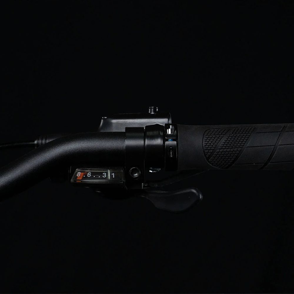 Lenker eines Fahrrads. Schalthebel mit Zahlen 1-6. Schwarze Griffe.