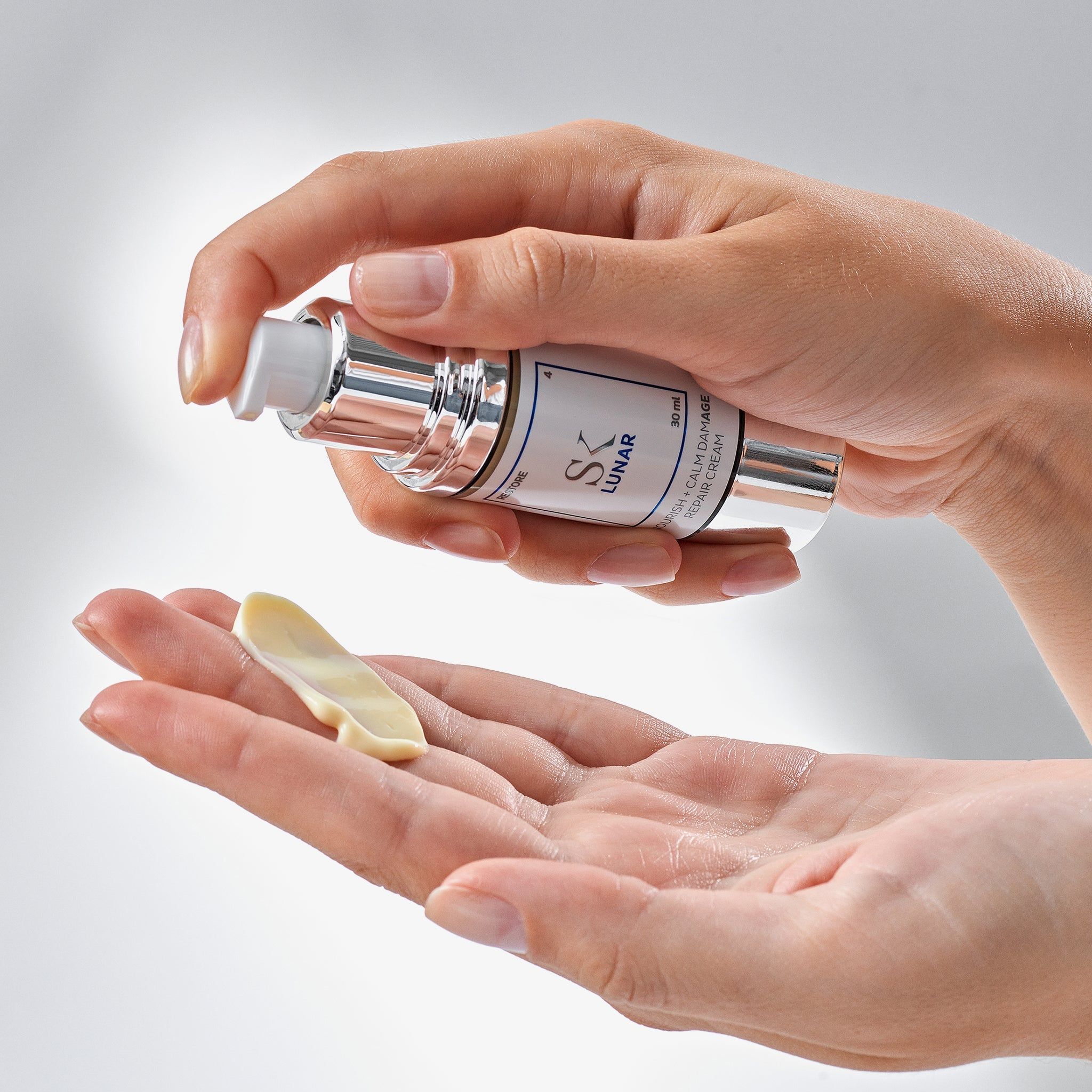 Mani che tengono erogatore di crema e crema. Scritta: SK Lunar, Nourish + Calm Damage Repair Cream.