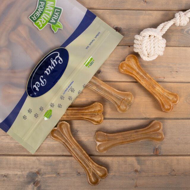 Geöffnete Verpackung mit Kauknochen. Aufdruck: Lyra Pet, Lyra Nature Power. Daneben liegen weitere Kauknochen.