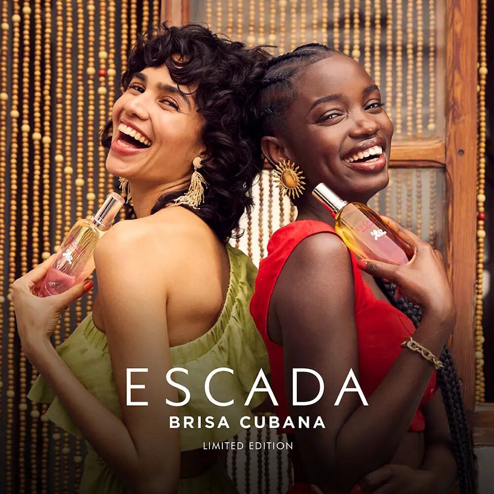 Zwei Frauen halten Escada Brisa Cubana Parfümflaschen. Aufschrift: Escada Brisa Cubana Limited Edition. Beide lächeln.