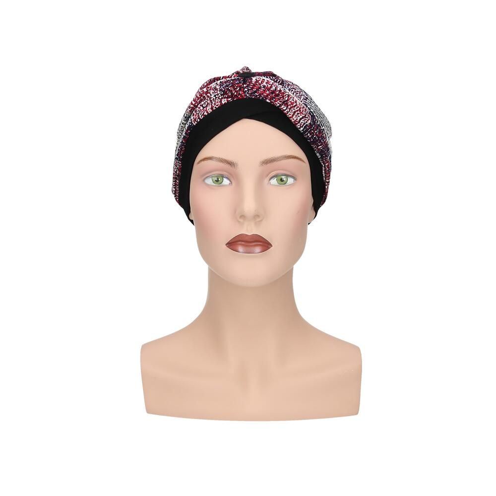 Turban mit mehrfarbigem Muster auf einem Schaufensterpuppenkopf. Schwarzes Stirnband. Frontansicht.