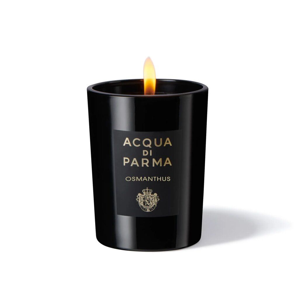 Schwarze Kerze mit Flamme. Aufschrift: Acqua di Parma, Osmanthus. Logo. Kerze in Glas. Brennende Flamme.
