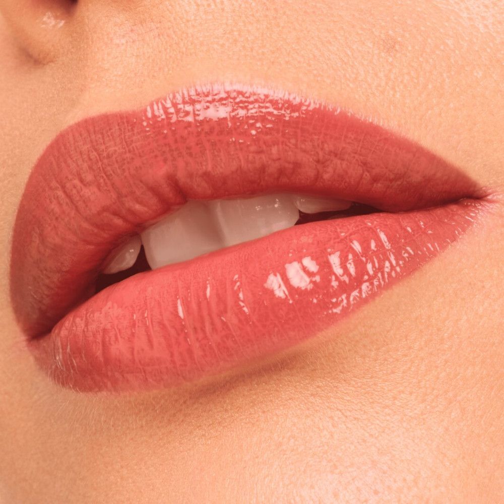 Nahaufnahme von Lippen mit Lip Tint. Glänzendes Finish. Rosa Farbton.
