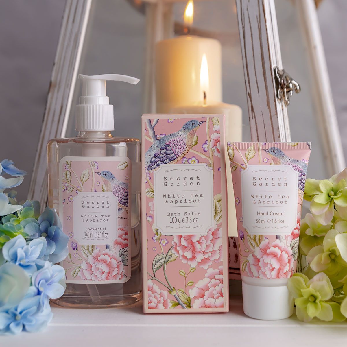 Duschgel, Badesalz und Handcreme mit floralem Design und Kerze.