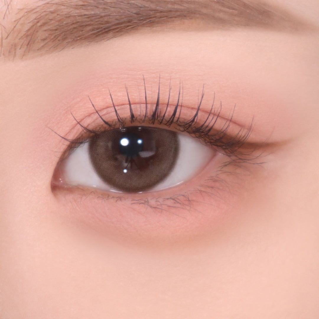 Auge mit rosa Lidschatten und braunem Eyeliner. Braune Augenfarbe.