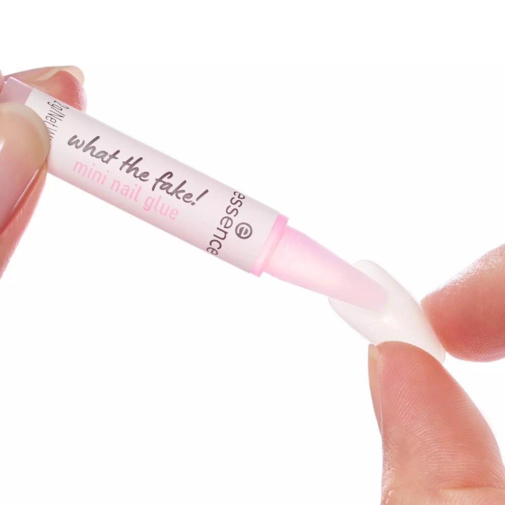 Hand hält Mini Nagelkleber und künstlichen Nagel. Aufschrift: what the fake! mini nail glue. Marke: essence.