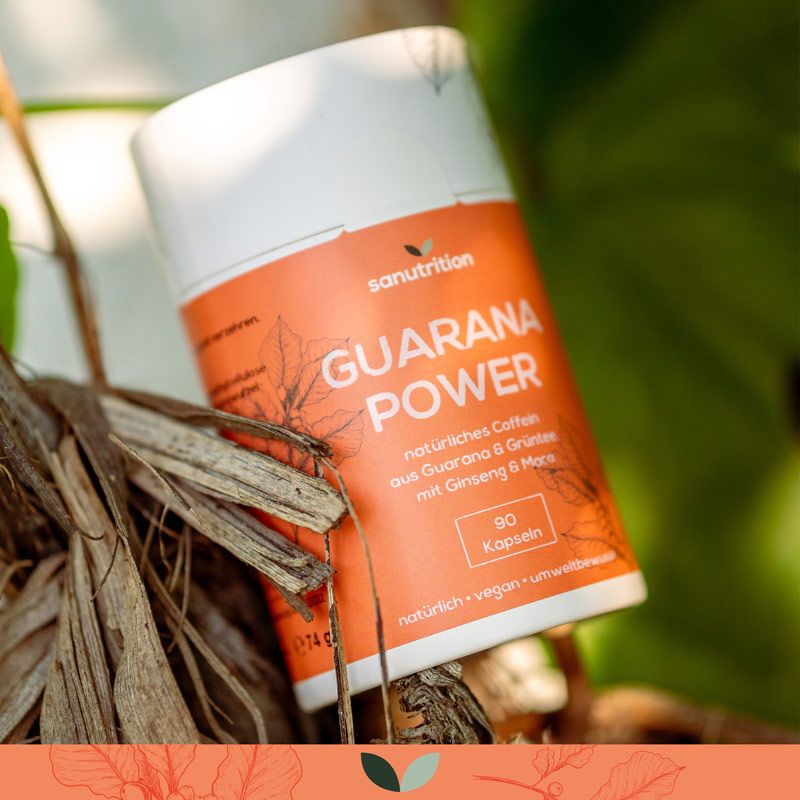 Zylindrische Dose "Guarana Power" in natürlicher Umgebung. Orangefarbener Aufdruck mit Produktinformationen. 90 Kapseln.