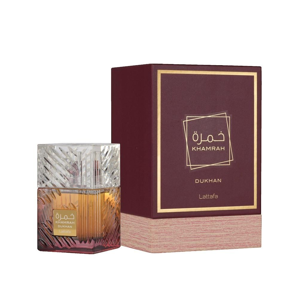 Parfümflakon und Verpackung. Quadratischer Flakon mit goldfarbenem Inhalt und transparentem Deckel. Burgunderrote Verpackung.