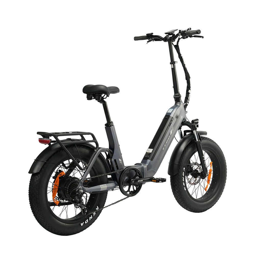 Graues Klapp-E-Bike mit schwarzen Reifen und orangefarbenen Akzenten. Das Fahrrad hat einen Gepäckträger und hydraulische Scheibenbremsen.
