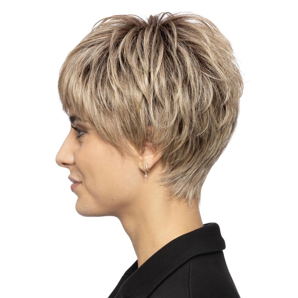 Kurzhaarperücke in Blondtönen. Seitenansicht einer Frau mit Perücke. Kurzer, fransiger Pony. Die Frau trägt einen schwarzen Blazer.
