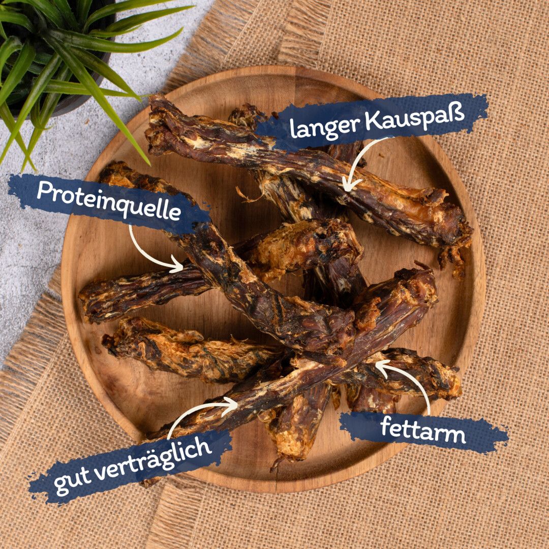 Lyra Pet® Entenhälse auf Holztablett. Beschriftungen: Proteinquelle, gut verträglich, fettarm, langer Kauspaß.