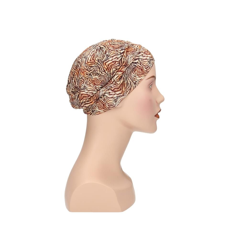 Turban Sula von Turbane, Seitenansicht. Braun-beiges Muster. Auf einer Büste.