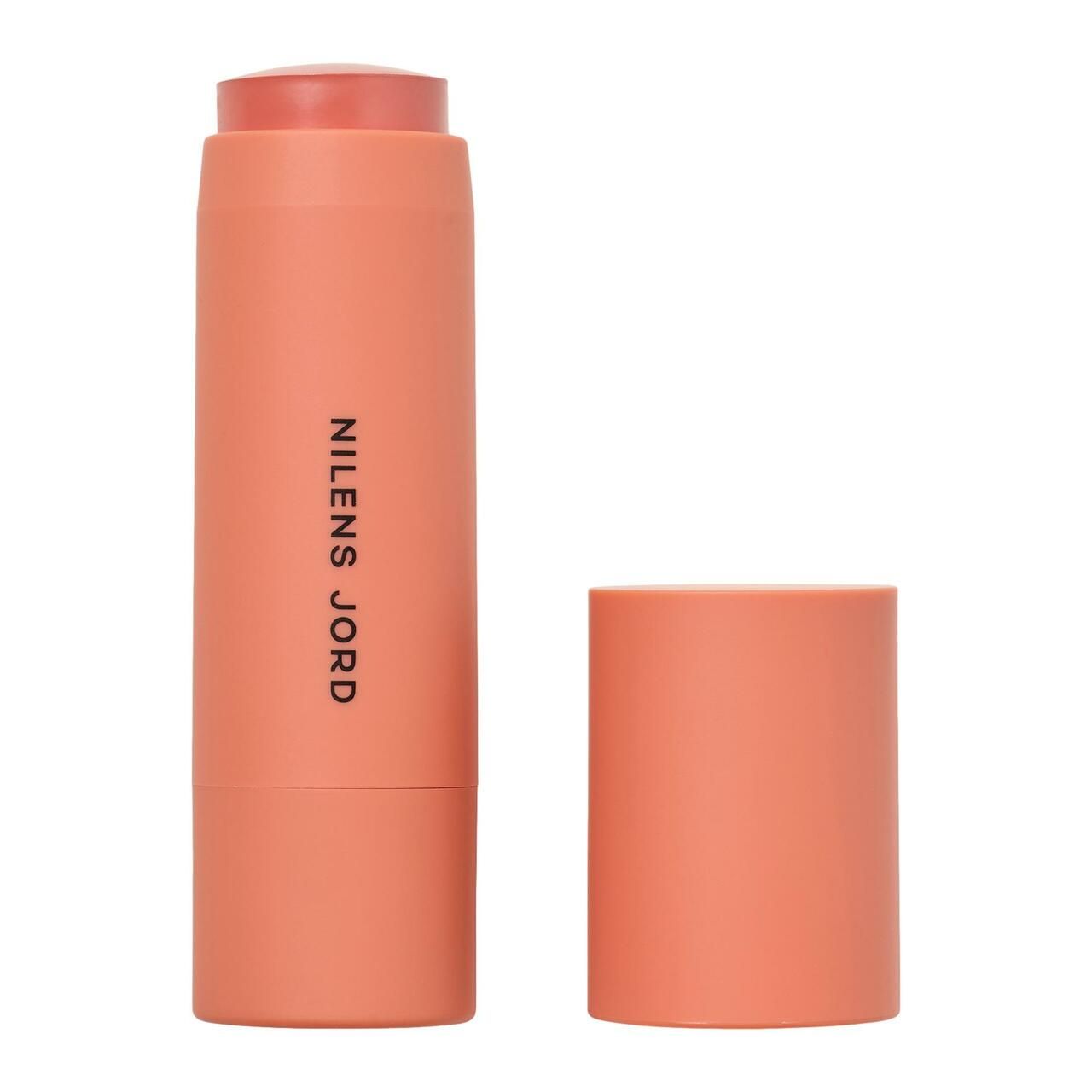 Zylindrischer Kosmetikstift, geöffnet. Rosa Produktspitze, korallenfarbener Behälter. Schriftzug: NILENS JORD.