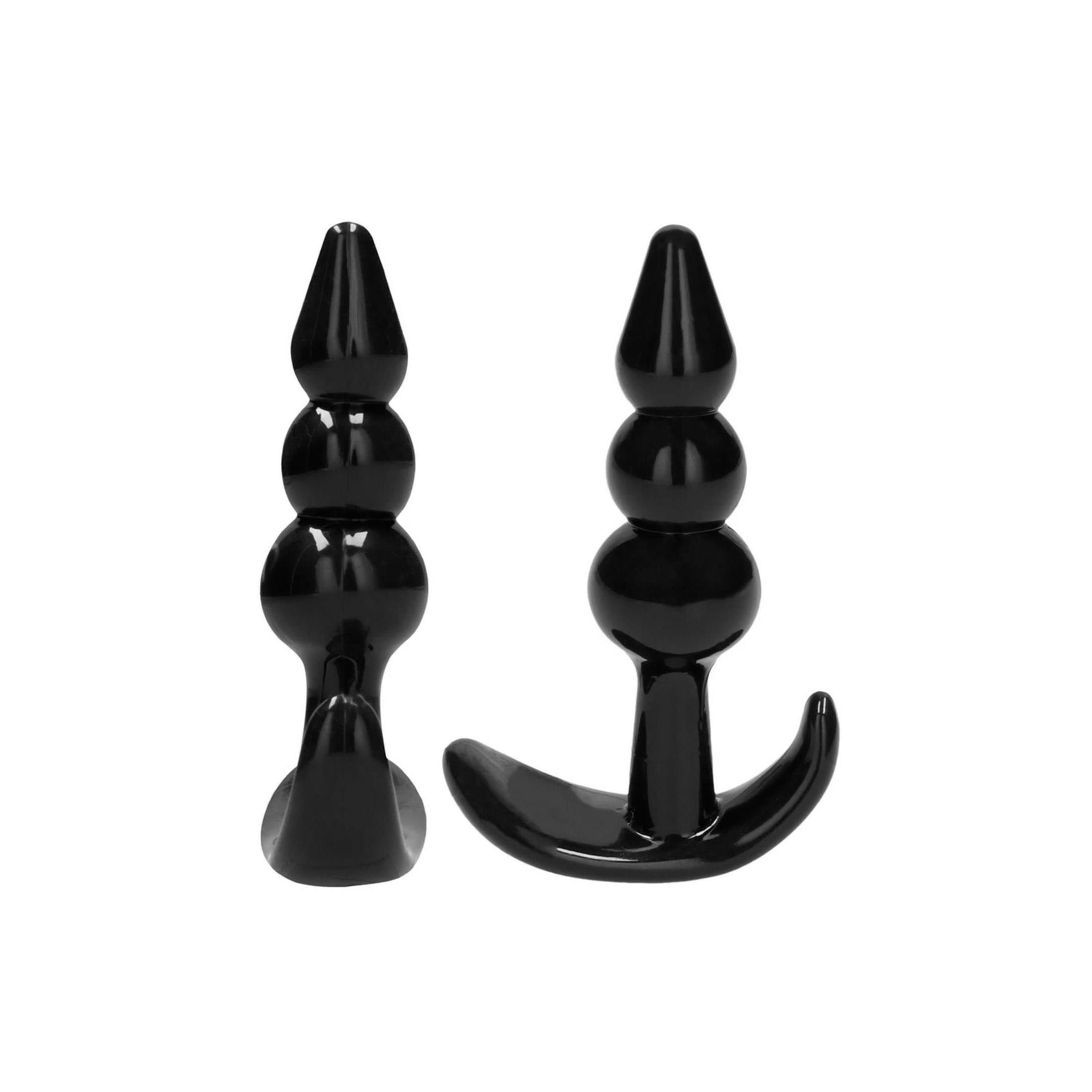 Zwei schwarze Anal-Plugs. Einer mit drei Kugeln, einer mit gebogener Basis.