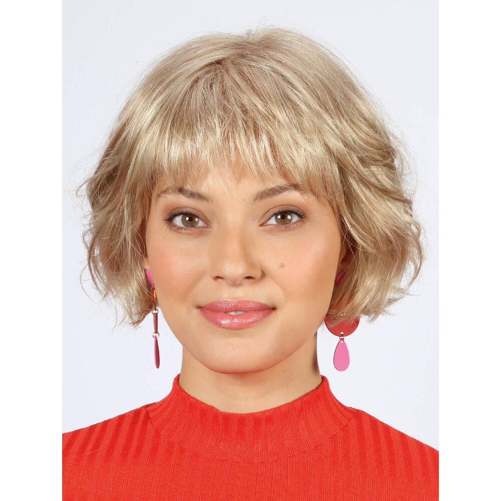 Weißblonde Perücke mit kurzem, gewelltem Schnitt. Frau trägt rotes Oberteil und rosa Ohrringe. Frontalansicht.