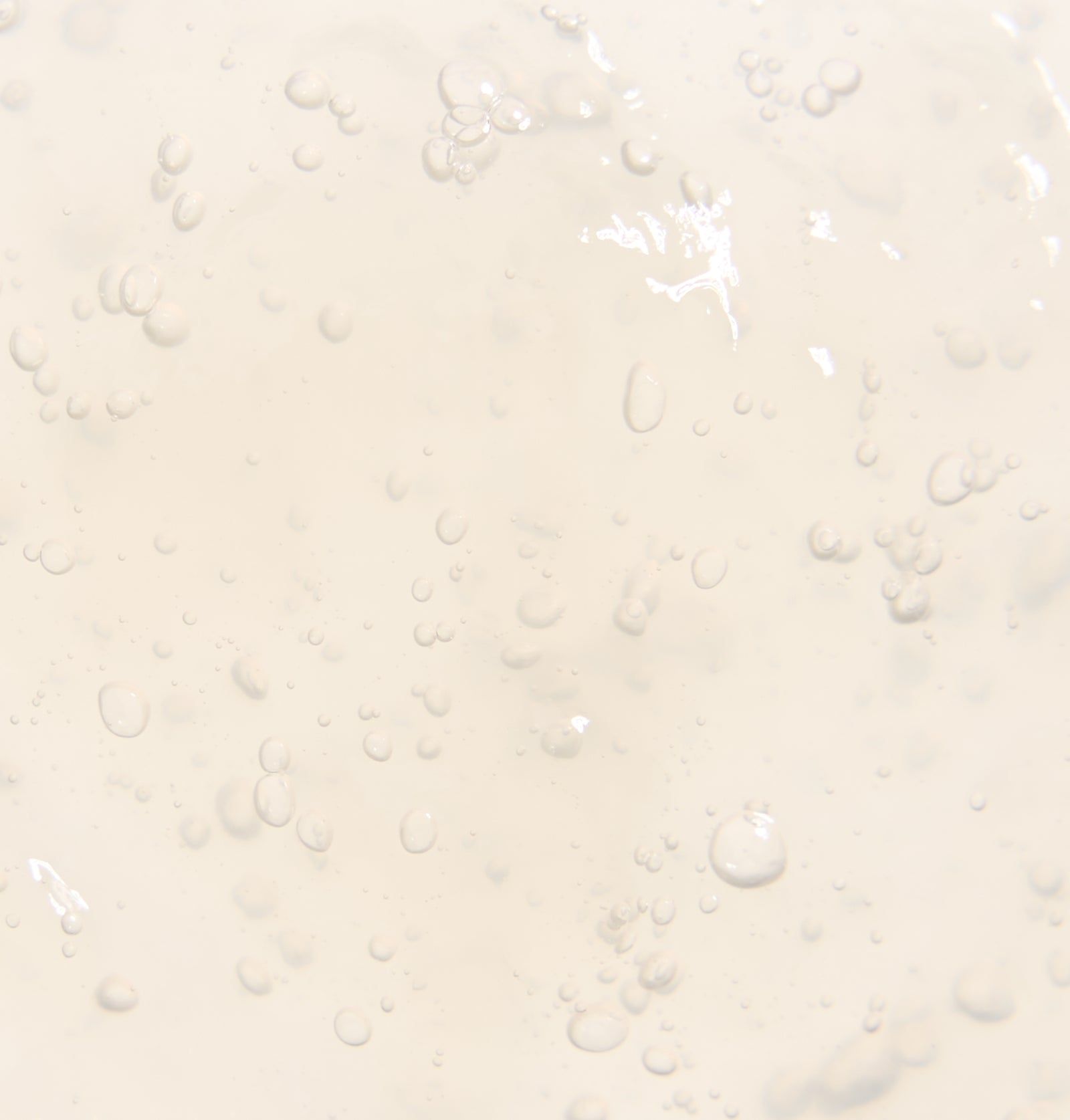 Nahaufnahme einer transparenten, gelblichen Flüssigkeit mit kleinen Blasen. Texturähnlich.