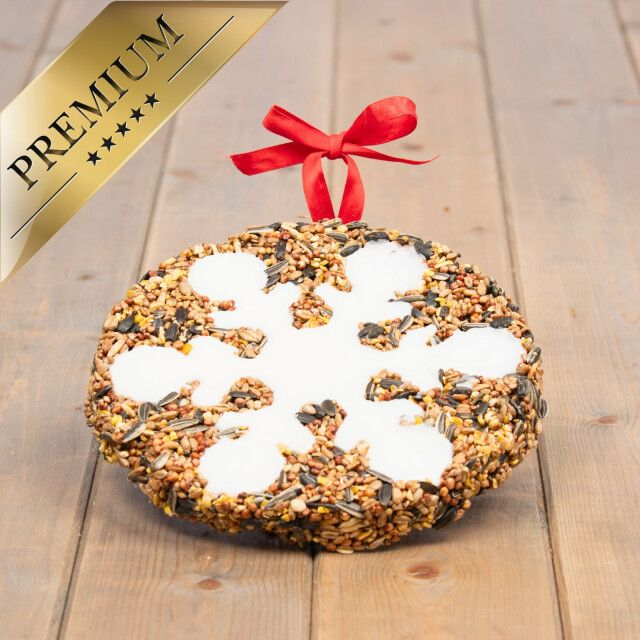 Runder Vogelkuchen mit Schneeflockenmuster. Goldene Plakette: PREMIUM. Rotes Band zum Aufhängen.