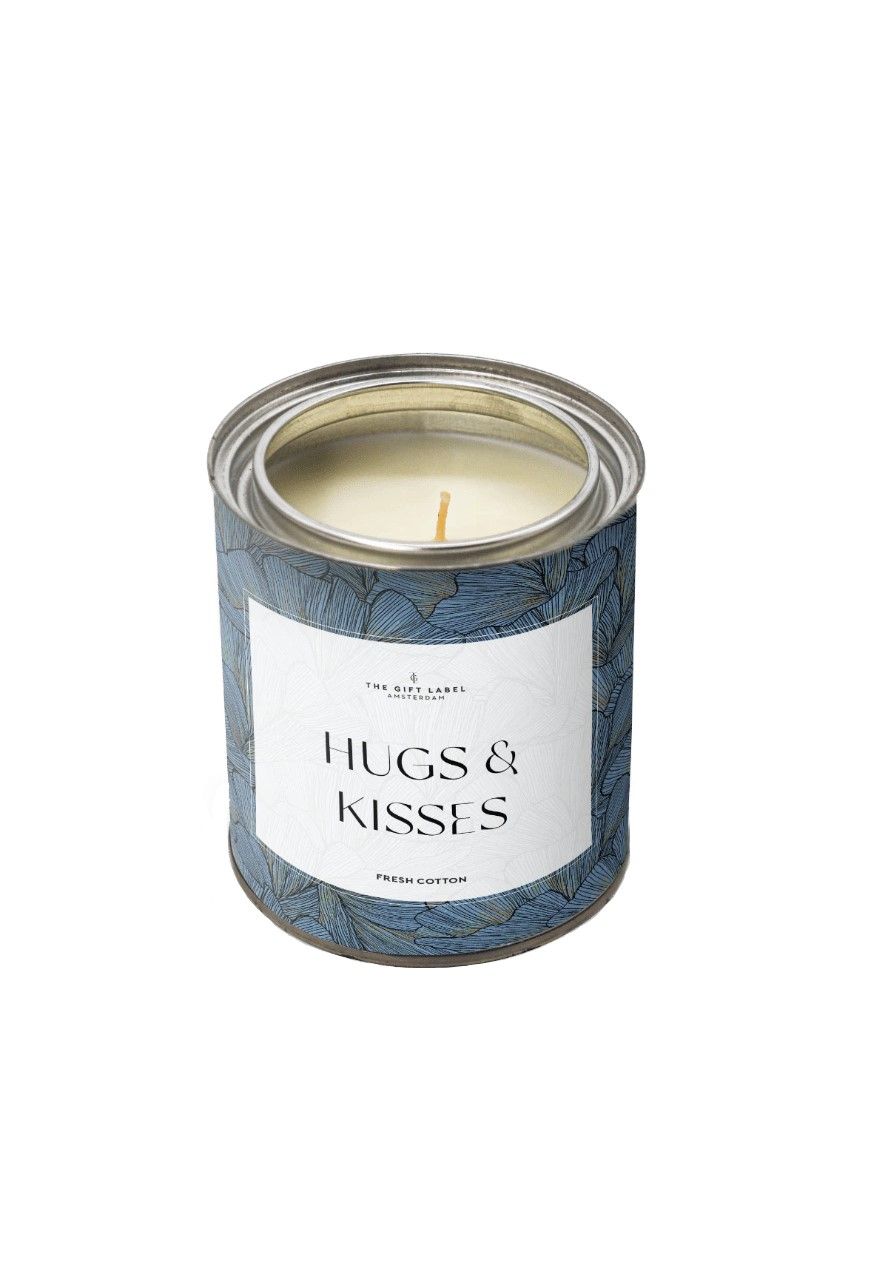 Kerze in einem Metallbehälter mit blauem floralem Muster. Aufschrift: HUGS & KISSES, Fresh Cotton. Docht sichtbar.