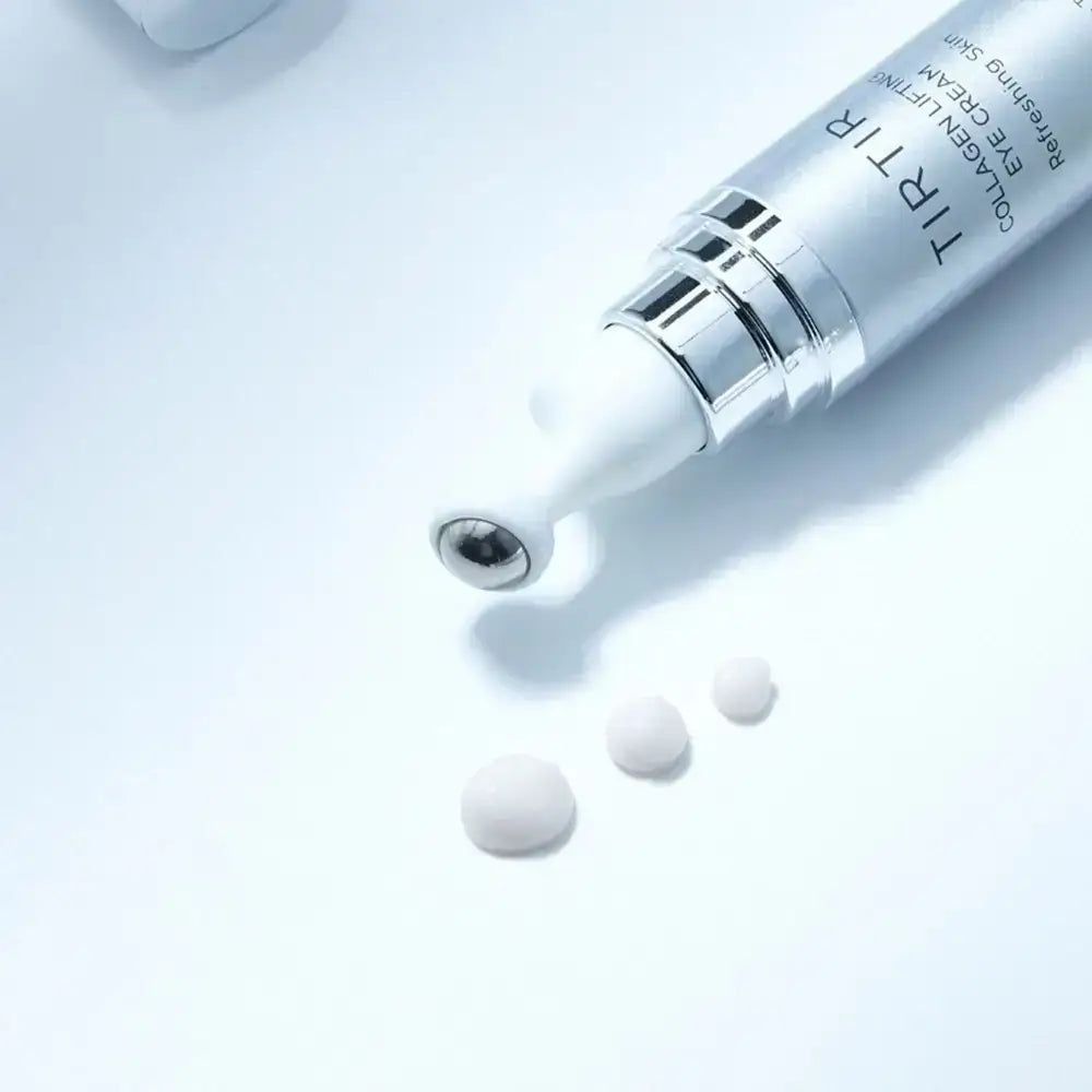 Silberne Tube mit Roll-on-Applikator und Creme-Tropfen. Text: TIR TIR COLLAGEN LIFTING EYE CREAM. Kühlende Metallkugel.