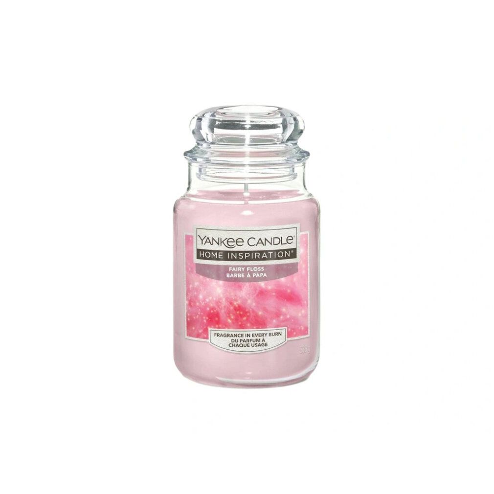 Duftkerze in einem Glasbehälter mit Deckel. Rosa Wachs. Auf dem Etikett steht "Yankee Candle Home Inspiration Fairy Floss".