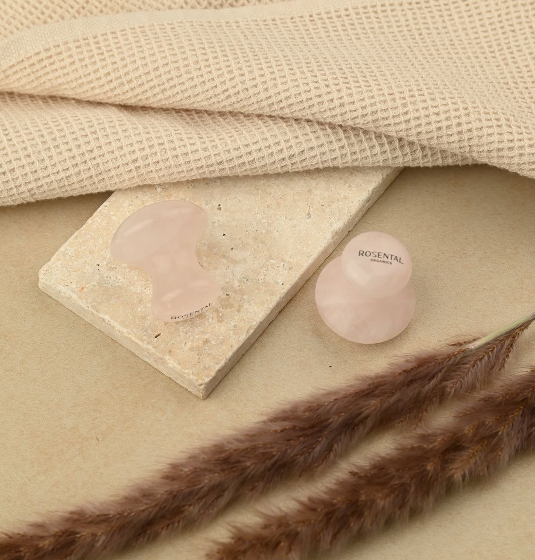 Zwei Rosental Organics Eye Flowies auf einer Steinplatte. Auf einem beigen Untergrund. Trockenblumen und Textil im Hintergrund.
