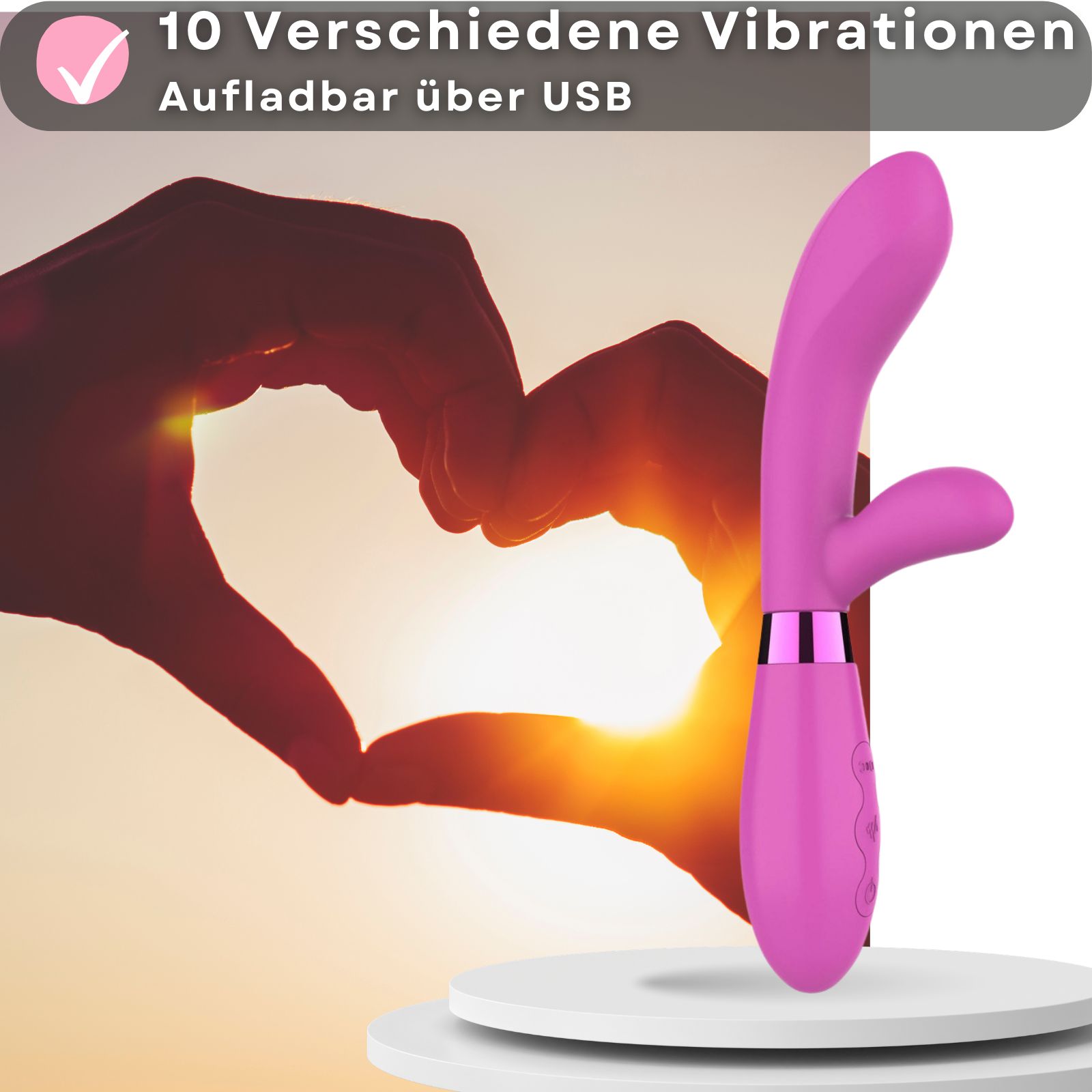 Rosa Vibrator. 10 Vibrationen. Aufladbar über USB. Herzform im Hintergrund. Auf Podest.
