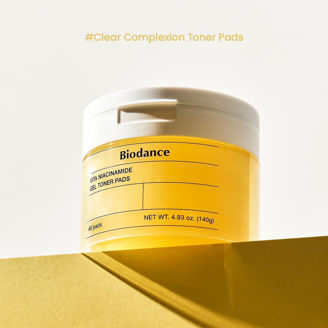 Weißer Behälter mit gelbem Toner. Aufschrift: Biodance, Vita Niacinamide Gel Toner Pads. Netto-Gewicht 4.93 oz (140g).