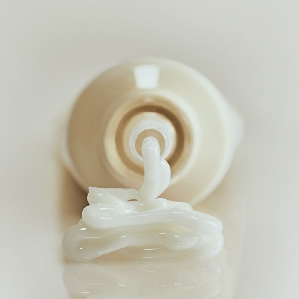 Tube "Abib Collagen eye crème", Creme wird herausgedrückt. Creme-Ausfluss auf hellem Hintergrund.