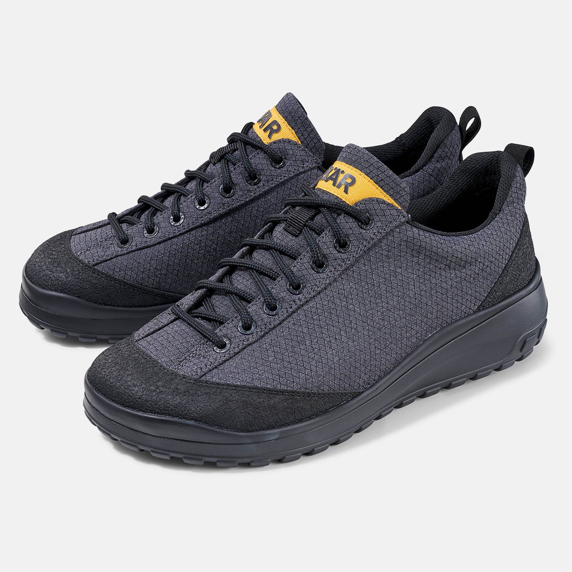 Zwei graue Herren-Schnürschuhe. Schwarze Sohle, Schnürsenkel und Details. Gelber Schriftzug BÄR auf der Zunge.
