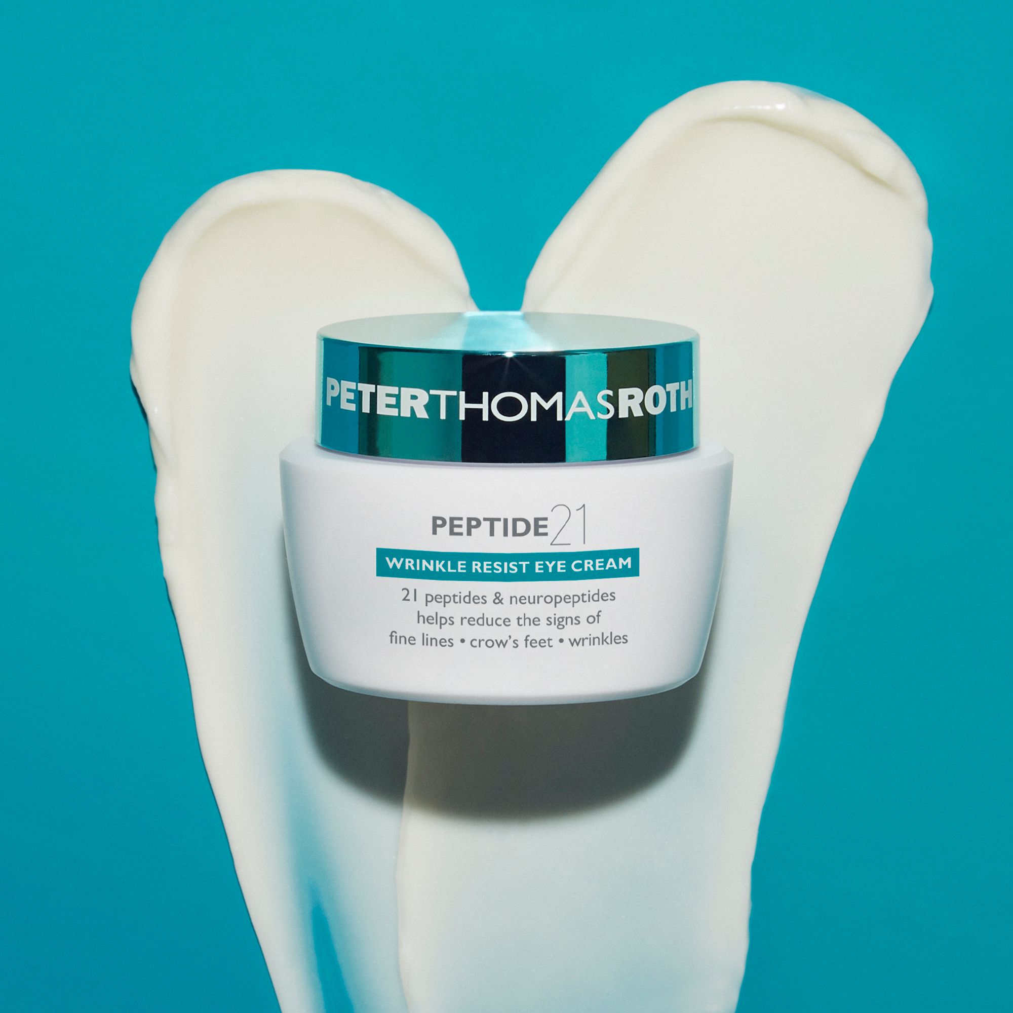 Peter Thomas Roth Peptide 21® Wrinkle Resist Eye Cream. Tiegel auf Creme-Klecks. Blauer Hintergrund.