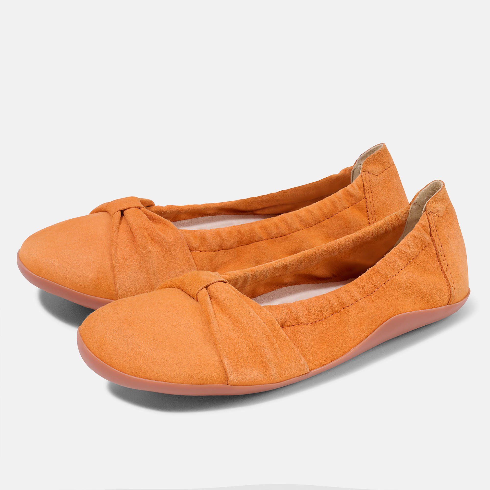 Zwei orangefarbene Ballerinas. Obermaterial aus Wildleder, Schleife vorne. Rosa Sohle. Weite Form.