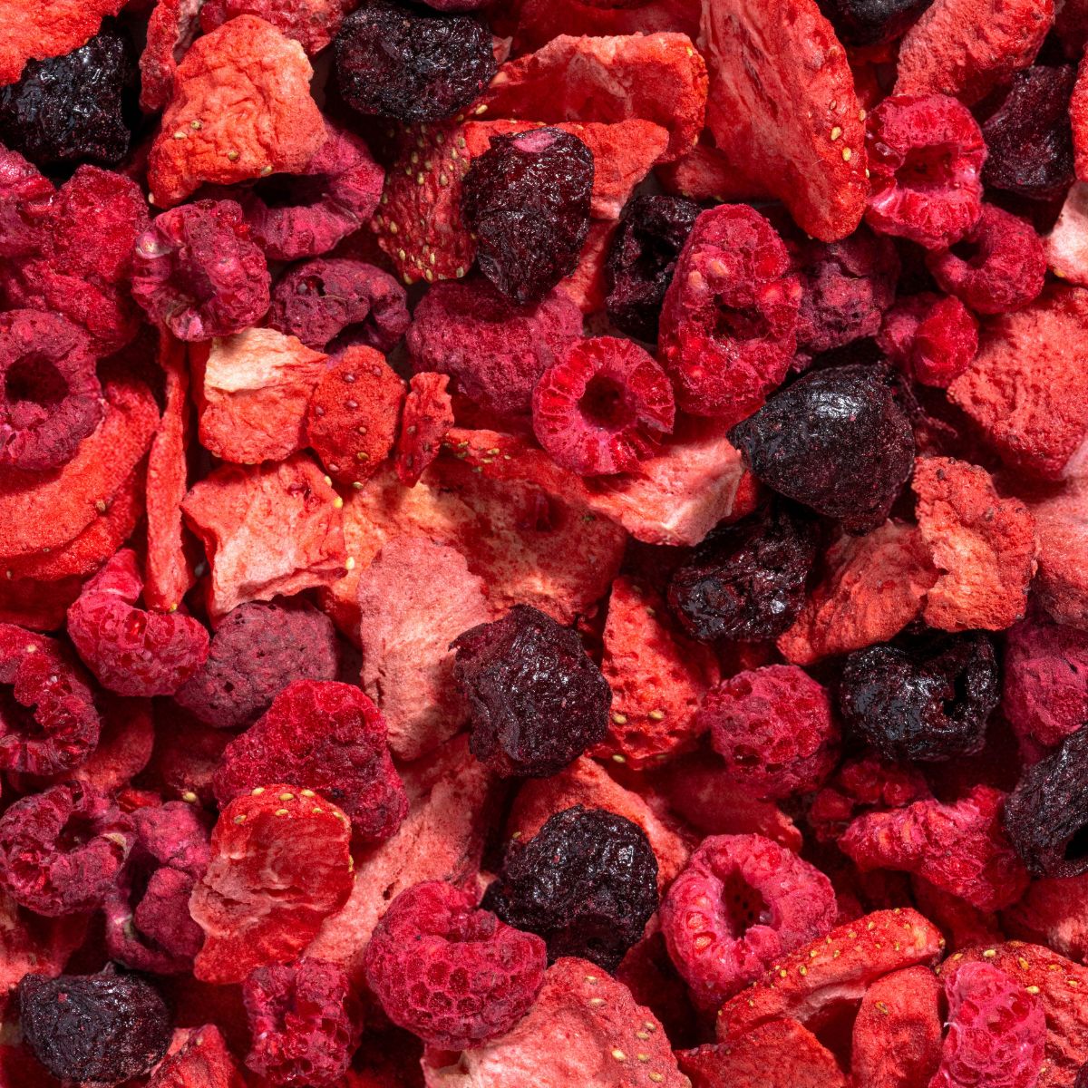 Nahaufnahme von gefriergetrockneten Kirschen und Beeren. Rote, violette und schwarze Früchte.