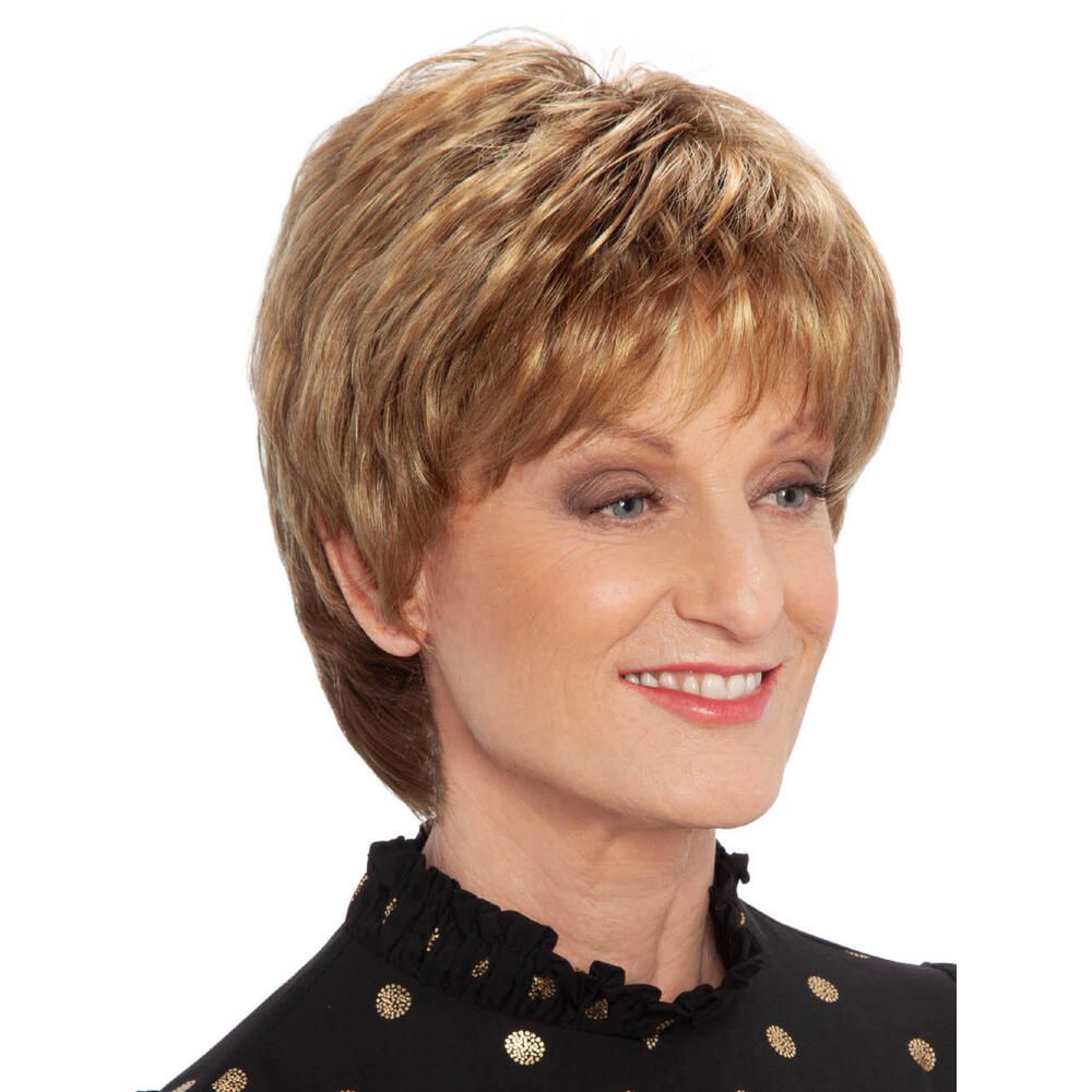 Kurzhaarperücke mit blonden Strähnen. Die Frau trägt ein schwarzes Oberteil mit goldenen Punkten.