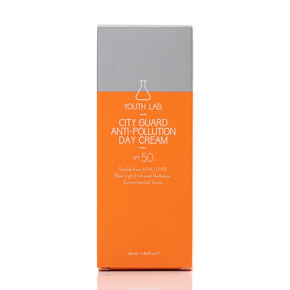 Orangefarbene Verpackung mit silbernem Deckel. Text: YOUTH LAB, City Guard Anti-Pollution Day Cream SPF50. Schützt vor UVA/UVB, blauem Licht, Infrarotstrahlung.