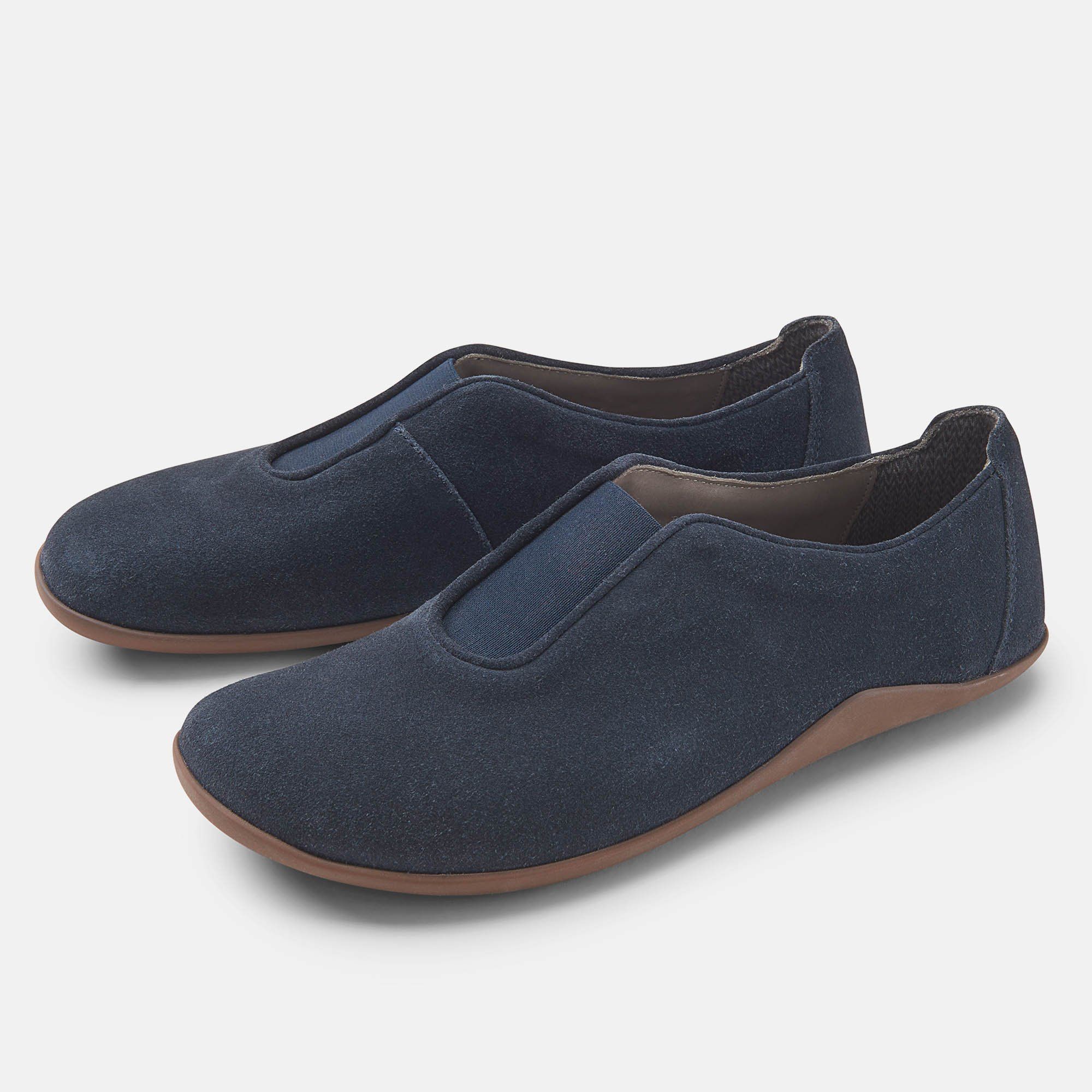 Zwei blaue Slipper mit brauner Sohle. Die Schuhe sind nebeneinander angeordnet.