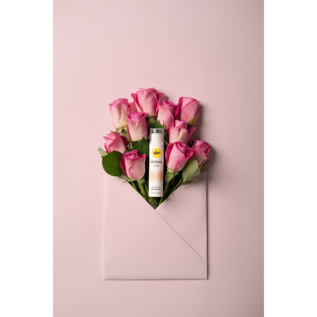 Produkt in Umschlag mit Rosen. Weiße Flasche mit gelbem Etikett. Produktname und Text. Text: Vibrating Orgasm Gel. Rosa Hintergrund.