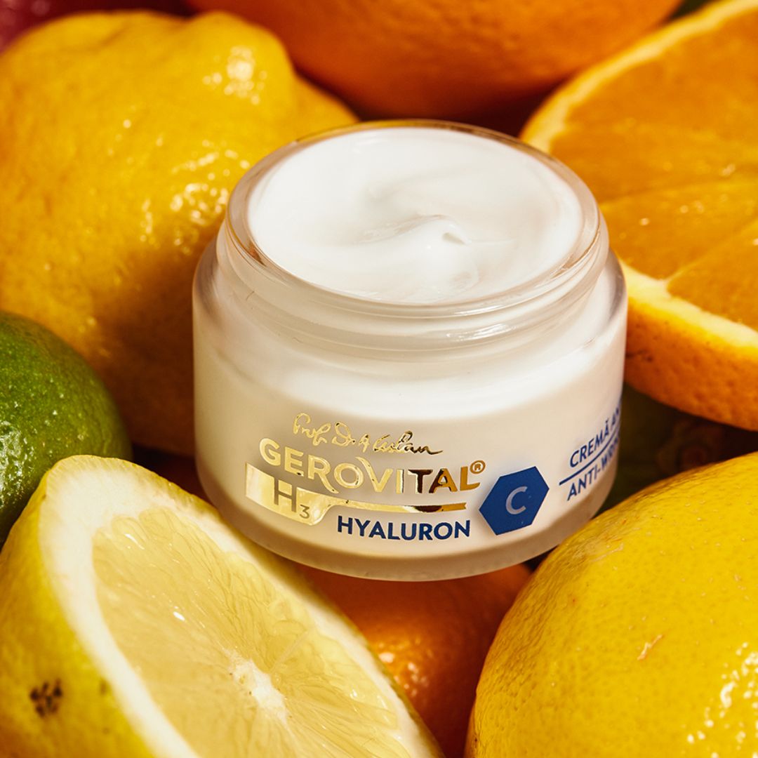 Creme-Tiegel mit Creme, umgeben von Zitrusfrüchten. Aufschrift: Gerovital H3 Hyaluron C. Creme Anti-Falten.