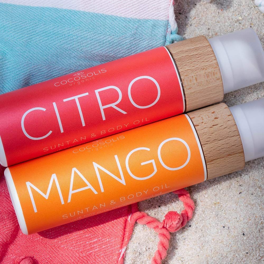 Zwei Flaschen auf Sand. Aufschrift: CITRO und MANGO. Marke: COCOSOLIS.