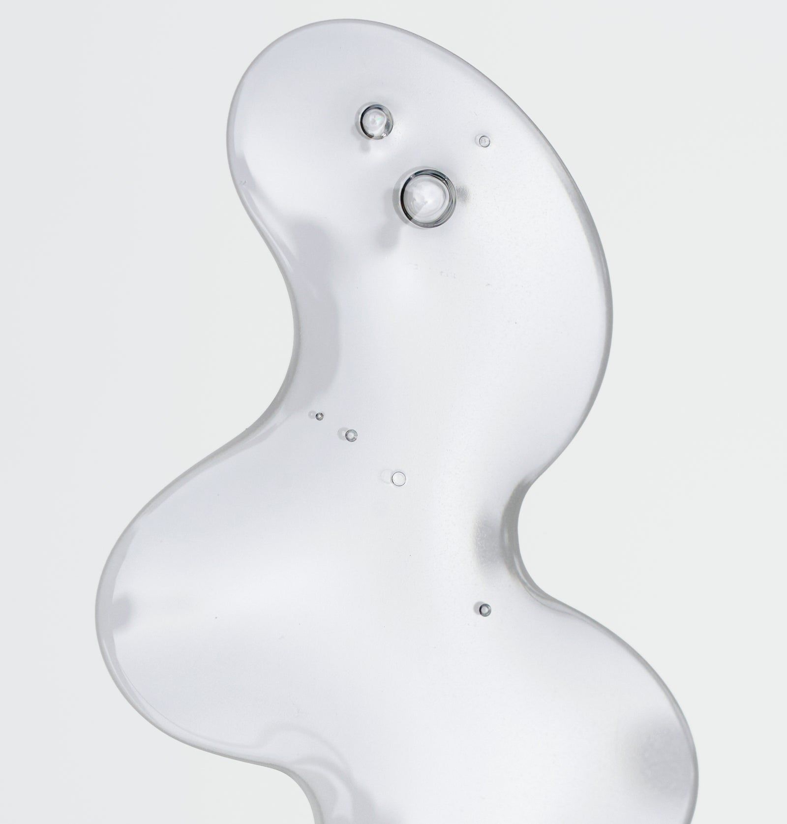 Nahaufnahme einer transparenten Flüssigkeit mit Blasen. Die Flüssigkeit hat eine wellenförmige Form.